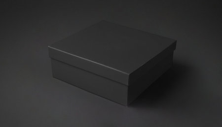 A simple closed black cardboard box on a dark background. Premium photo mockup for elegant and clean...