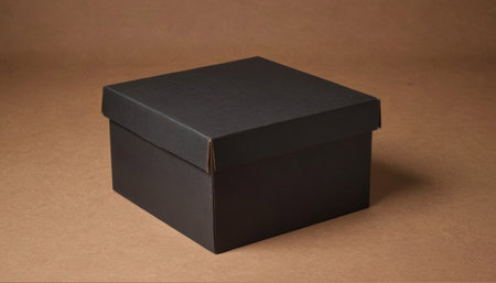 A closed square black cardboard box sits on a brown surface. Premium photo mockup for elegant and...