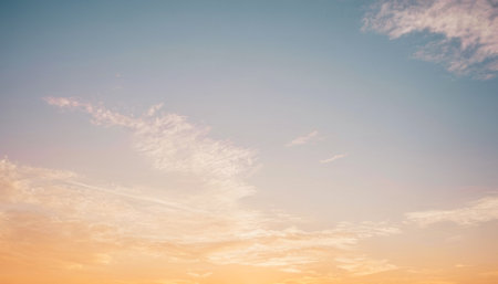 View of the sky at sunset with soft pink and orange hues and wispy cirrus clouds. Background photos...