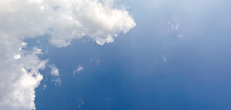 Single large white cloud dominates the left side of the image, contrasting against the clear blue sky. Beautiful clear sky daytime photos for website banners and so on.の写真素材