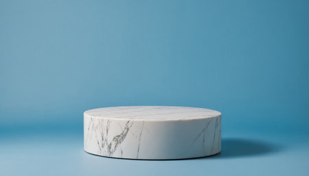 White marble pedestal sits on a blue background. Modern, elegant and clean look for product photography background purposes.の写真素材
