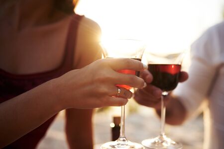 Lovers drink wine at sunset.