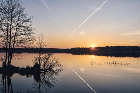 Sunset on the lake in the forest. Beautiful landscape.