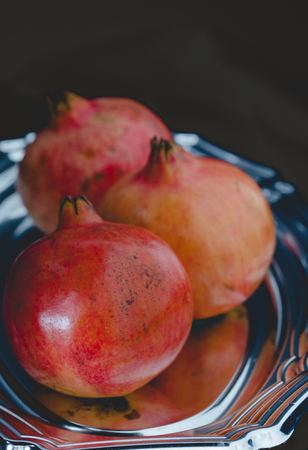 Close shot of pomegranates in tray and black background.の写真素材