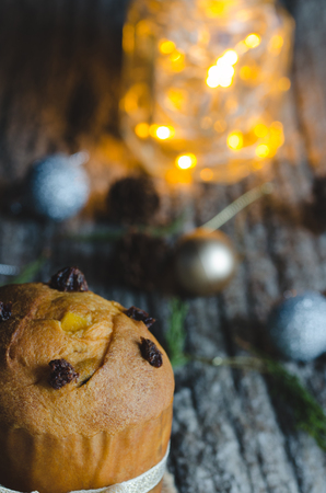Panettone with Christmas ornaments on wooden background with lights.の写真素材