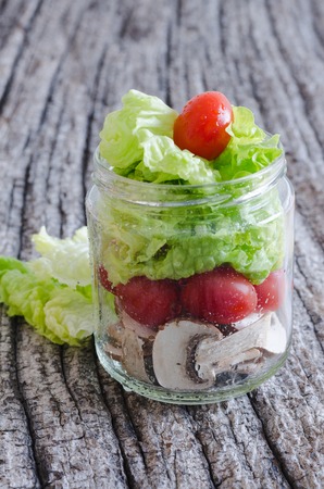 Glass jar with colorful vegetables on old wood. Top view.の写真素材