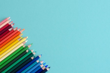 Colored pencils on blue background with space to write to the right. Top view.の写真素材