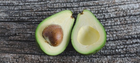 Avocado split in half on rustic board. Top view. Space to write.の写真素材