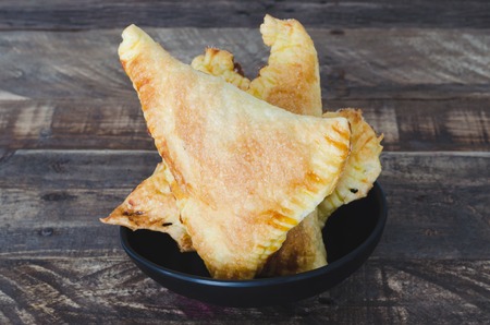 Puff pastry cake with caramel on wooden background. Coffee with milk.