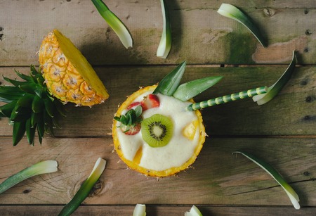 Pineapple cocktail with fruits in natural pineapple bowl. Top view.の写真素材