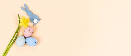 Easter eggs with rabbit figure and yellow daffodils. Copy space on the right. Concept of religion.の写真素材