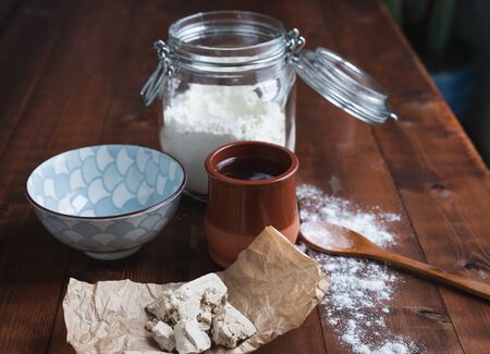 Bits of yeast on paper on a wooden base for making sourdough. Bakery concept.の写真素材