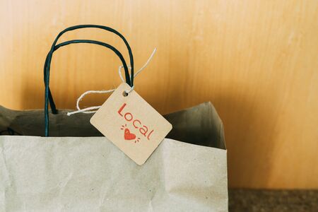 Paper shopping bag with label and LOCAL text on the front door. Concept of shopping.の写真素材