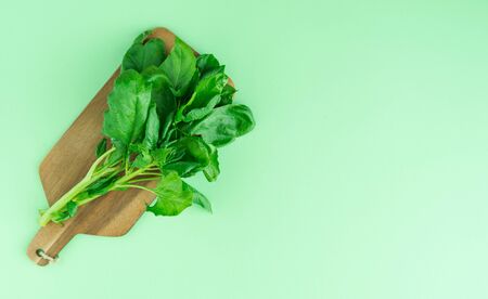 Table with spinach leaves on a blue wooden background. Copy space on the right. Concept Vegetables. Top view.の写真素材