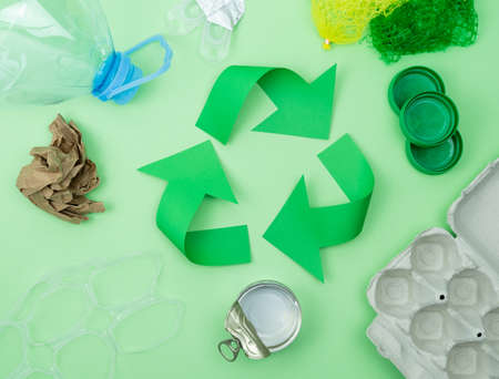 Recycling logo on green background with objects to recycle.の写真素材