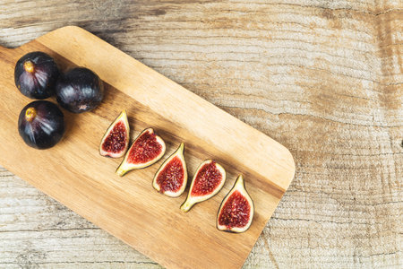Ripe figs cut and whole on a kitchen table on a wooden base. Copy space.の写真素材