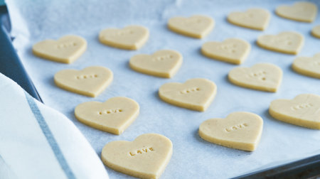Process of making heart-shaped cookies with the word LOVE ready to bake. Pastry Concept.