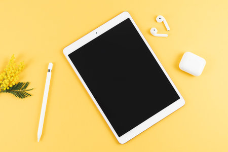 Tablet with headphones and pencil on yellow background. Top view. Copy space.の写真素材