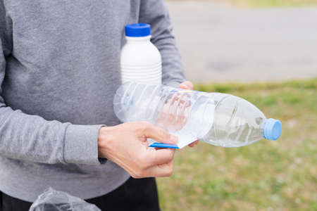 Man throwing plastic containers at recycling point. Social responsibility. Recycling concept.
