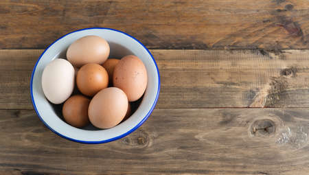 Bowl with boiled eggs on wooden background. Copy space. Top view.の写真素材