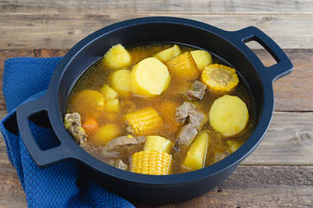 Colombian Sancocho freshly made in a pot on a wooden bottom. Copy space.の写真素材