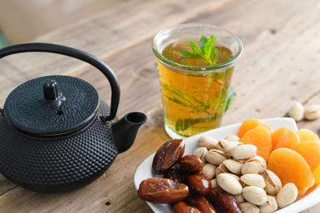 Dried fruit tray with tea glass on wooden background. Copy space.の写真素材