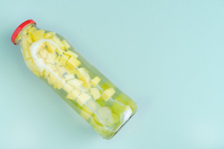 Glass bottle with fruit water on blue background. Copy space.の写真素材