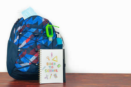 Notebook with text BACK TO SCHOOL with backpack and white background. Copy space.の写真素材