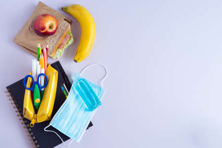 Back to School material. Pencils, notebook and sandwich on purple background. Copy space.の写真素材