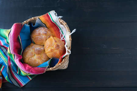 Bread of the dead in wooden basket on black background. Day of the dead. Mexican holiday. Copy space.の写真素材