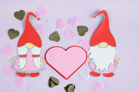 Gnomes couple cut out of paper with hearts on lilac background. Valentine's Day. Copyspace.の写真素材