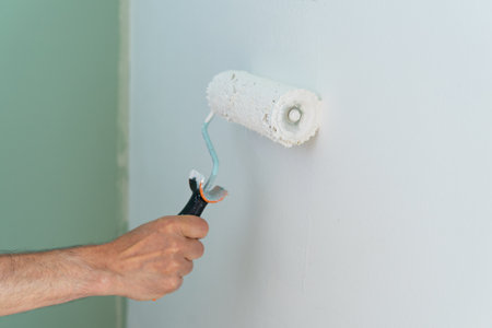 Close-up of hand painting the wall with a roller. Copyspace. Horizontal shot.の写真素材