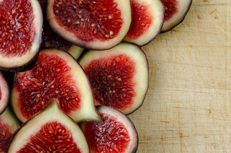 Macro photograph of ripe figs cut in half on used board. Copyspace. top view.