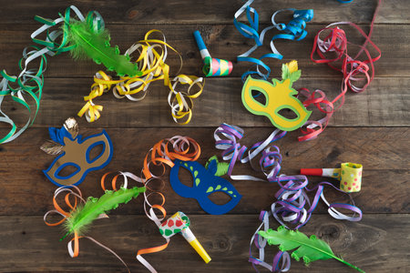 Carnival decoration on rustic wooden background. Masks with ribbons and other carnival elements.の写真素材