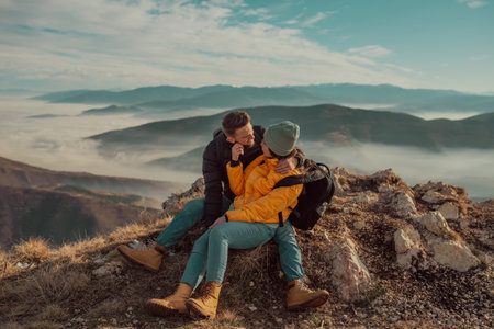 happy couple man and woman tourist at top of mountain during a hike in summerの写真素材