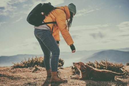 Girl with a dog play in the mountains. Autumn mood. Traveling with a pet.Woman and her dog posing outdoor.の写真素材
