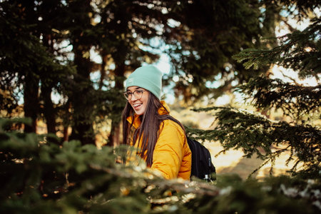 a portrait of a woman walking through the woods on a sunny day