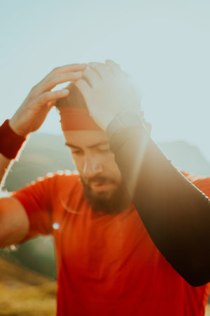 A determined athlete preparing for the start of training on the top of the mountain at sunrise.