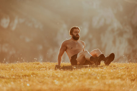 A man doing abs exercises on top of a mountainの写真素材