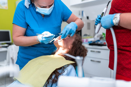 Dentist appointment at a dental clinic, placing braces locks on the teeth and pulling the archwire to fix itの写真素材
