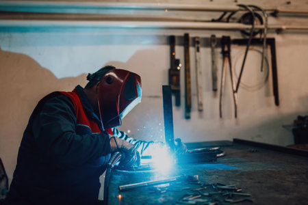 Welder erecting technical steel. Industrial steel welder in factory technical