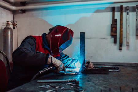 Welder erecting technical steel. Industrial steel welder in factory technical