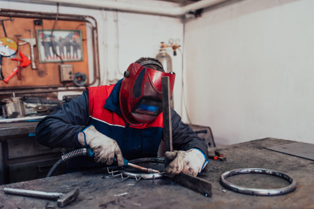 Welder erecting technical steel. Industrial steel welder in factory technical