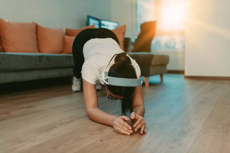 A woman stretching in her apartment during early morning after training , reflecting her dedication...