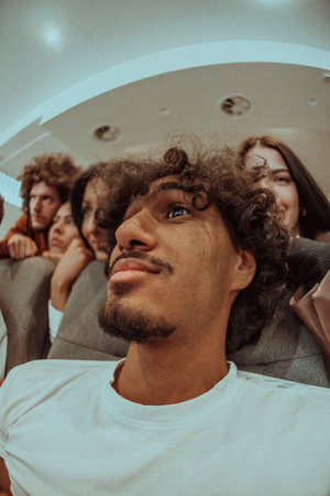 A diverse group of friends with terrified expressions together in a cinema to watch a horror film, experiencing a mix of fear, excitement, and laughter, as they collectively navigate through suspenseful and chilling momentsの写真素材