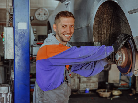An automotive mechanic in his workshop, diligently repairing the brakes on a car with precision and expertiseの写真素材