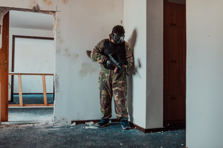 Paintball player in mask who is aiming in opponents at paintball arena. Selective focusの写真素材