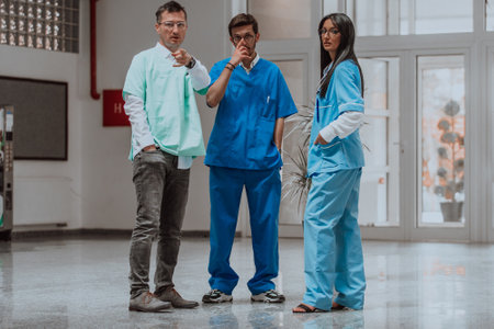 A nurse, medical technician, and doctor engage in a discussion on various medical topics in a modern, high-tech hospital, showcasing teamwork, expertise, and the utilization of advanced technology to drive innovation and provide excellent patient care in a multidisciplinary and progressive healthcare environmentの写真素材
