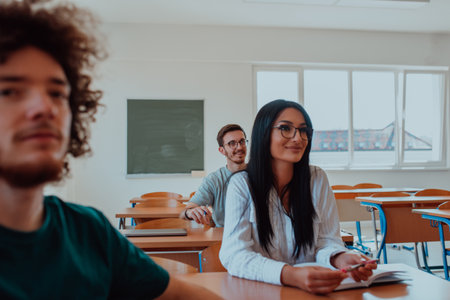 A group of diverse students engages in lively discussion as they educate themselves in a modern classroom, embracing the power of collaboration and knowledge exchange.の写真素材