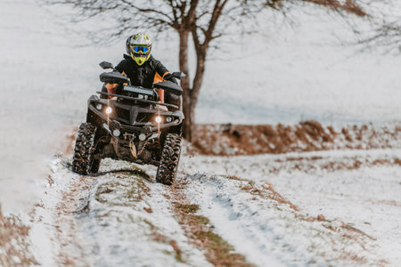 A young adventurous couple embraces the joy of love and thrill as they ride an ATV Quad through the snowy mountainous terrainの写真素材